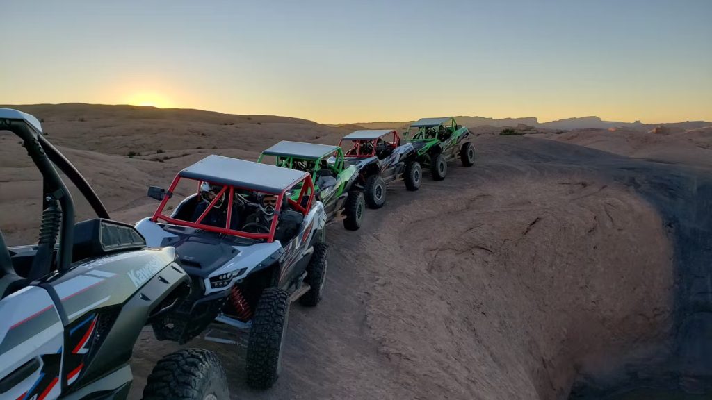 Four UTVs parked on a dirt road, ready for an epic adventure.