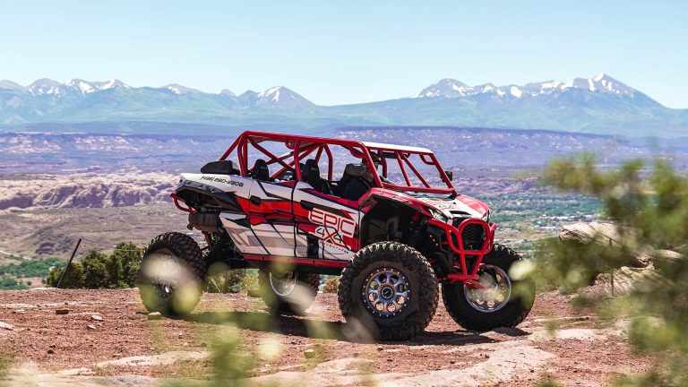A red and white UTV parked on a dirt road, gearing up for some epic off-road adventures