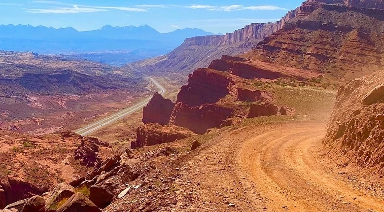 Experience the thrill of off-roading on a desert dirt road, surrounded by rocks